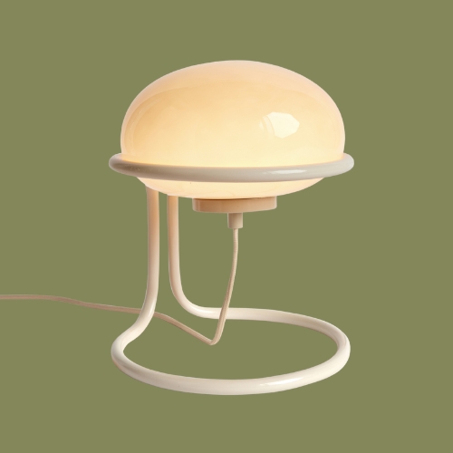 Image of a modern cream table lamp on a dark green background.