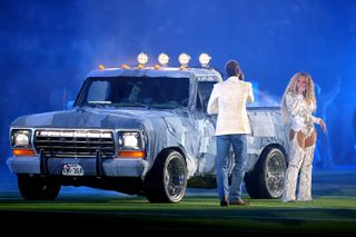 Post Malone sings next to beyonce and a denim covered truck