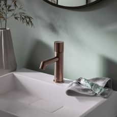 Brass bathroom mixer tap on a white basin