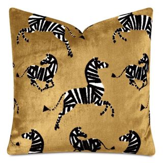 A mustard yellow velvet throw pillow with zebras on