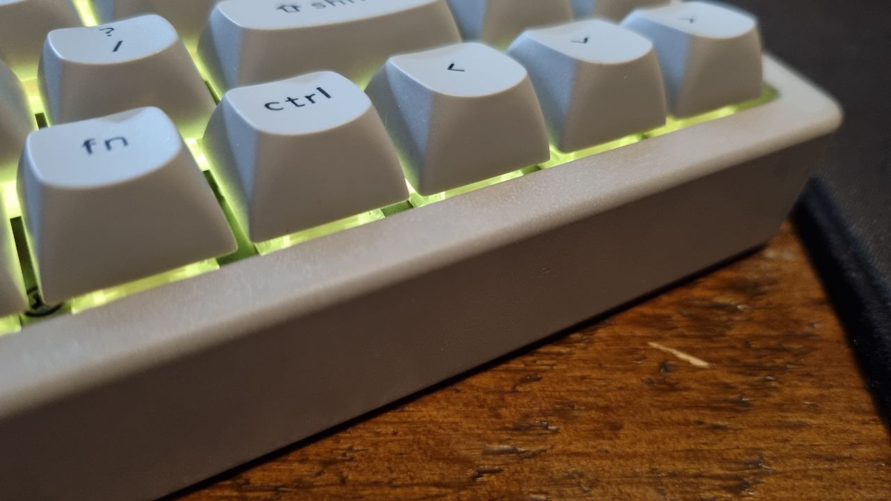 Various angles of a Keychron K2 HE Concrete Edition keyboard lit up in RGB lighting