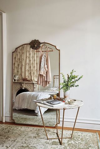 bedroom with large antique looking mirror by anthropologie