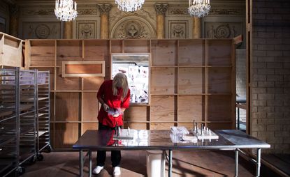 Woman in a red uniform and blonde wig making chocolate from moulds