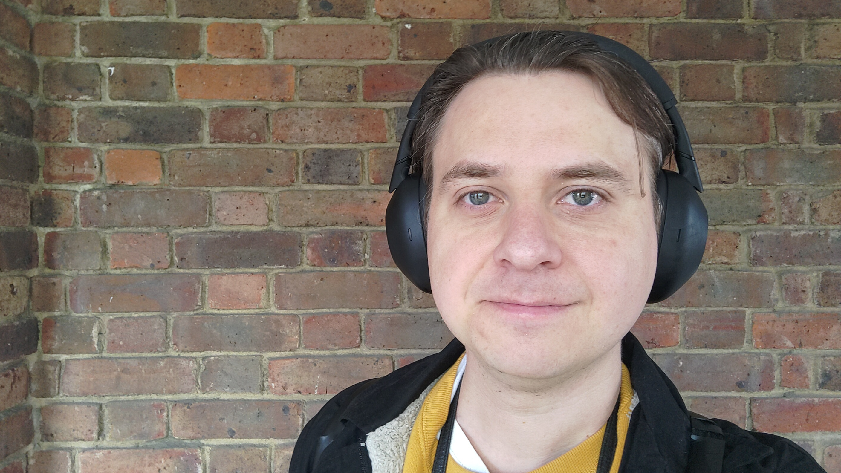 Photograph of man wearing Sony WH-1000XM6 headphones