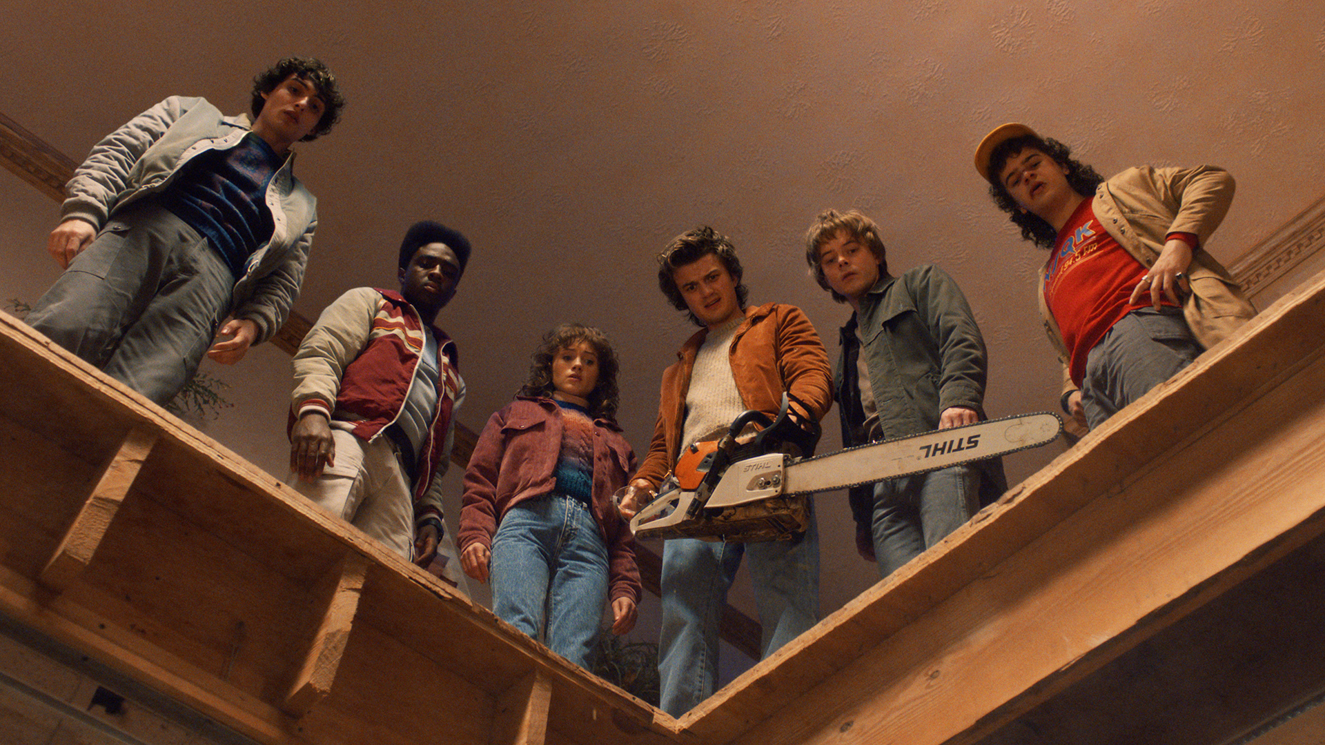 Mike, Lucas, Nancy, Steve, Jonathan, and Dustin looking down from a roof in Stranger Things season 5