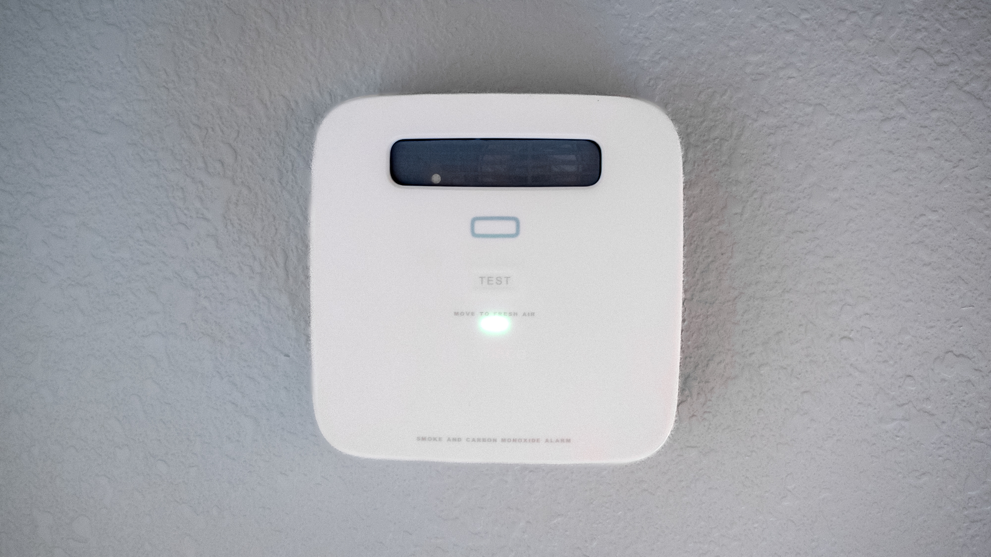 A Place smoke alarm mounted on a wall