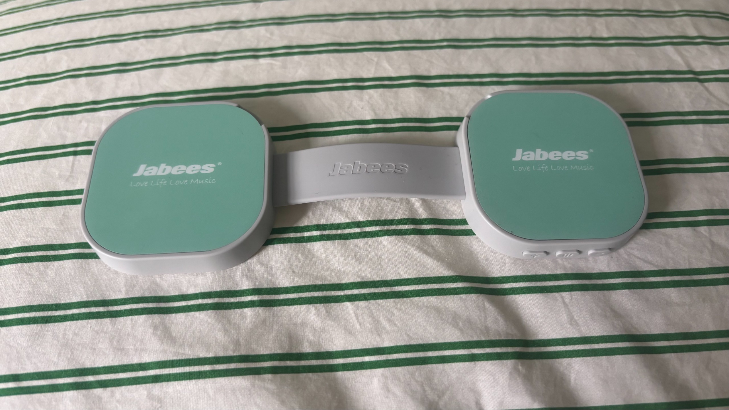 The Jabees PEACE Duo Pillow Speaker on a tandem stripe duvet cover.