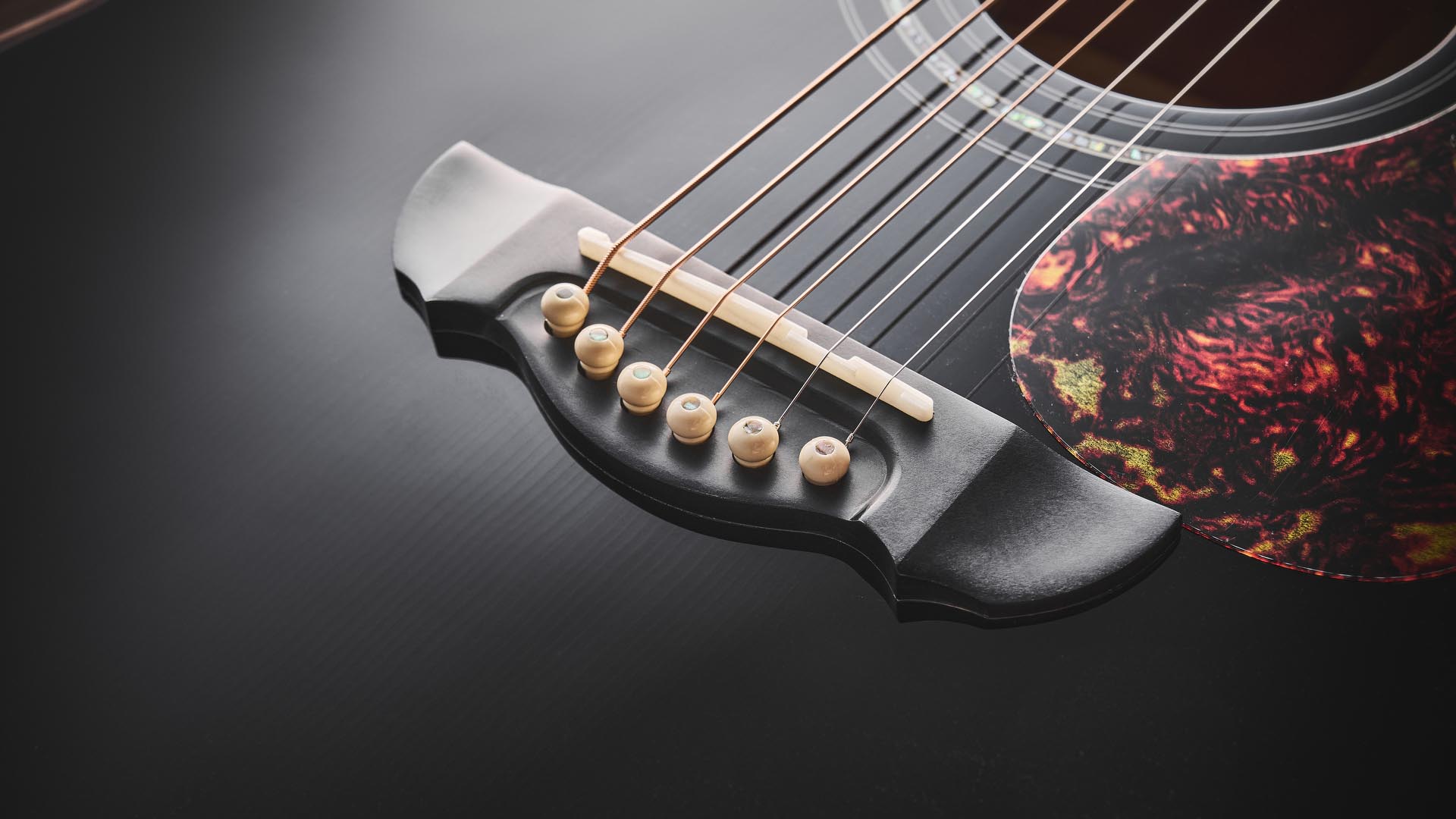 Harley Benton CLG-650SM-CE Black: the handsome but affordable cutaway acoustic isd photographed against a patterned rug on a wooden floor.