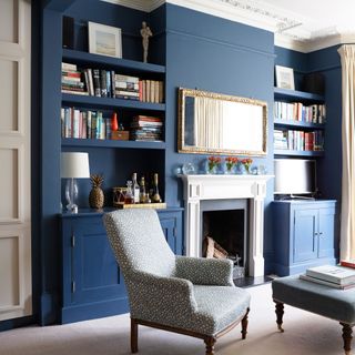 blue living room with gold mirror above fireplace