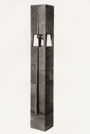 Elongated grey square tower with sections removed near the top