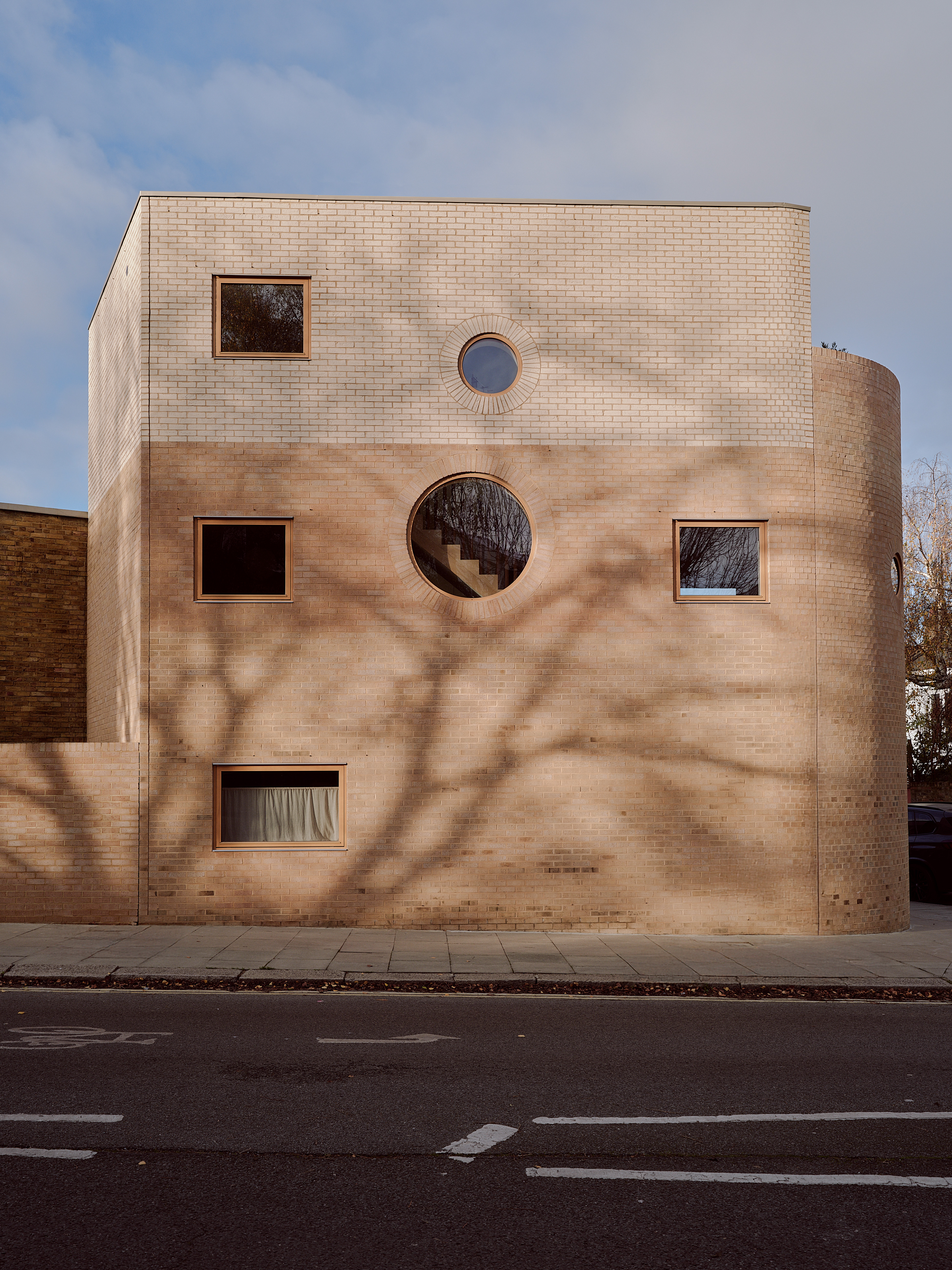 exterior shot of a home with brickwork, rounded edges and uneven fenestration