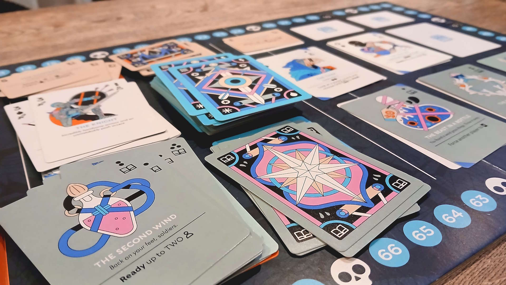 Multiple Fame &amp;amp; Fable cards on the board, which sits on a wooden table