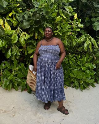 @abimarvel wearing a navy gingham dress and brown Birkenstocks