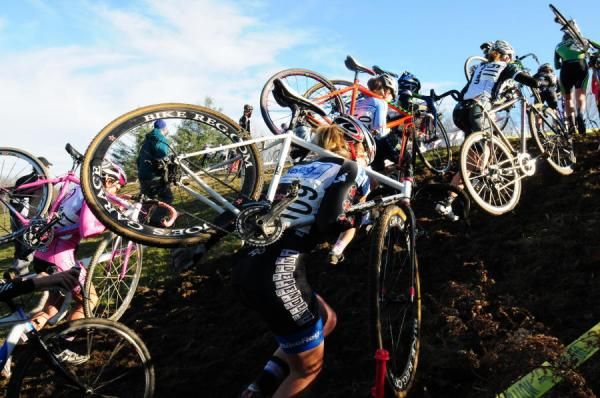 Elite women climb a steep hill en mass