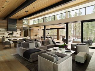 open plan living dining kitchen with glass walls and wooden cladding taupe sofas