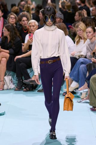 a Prada model walks the spring/summer 2025 runway in skinny leggings