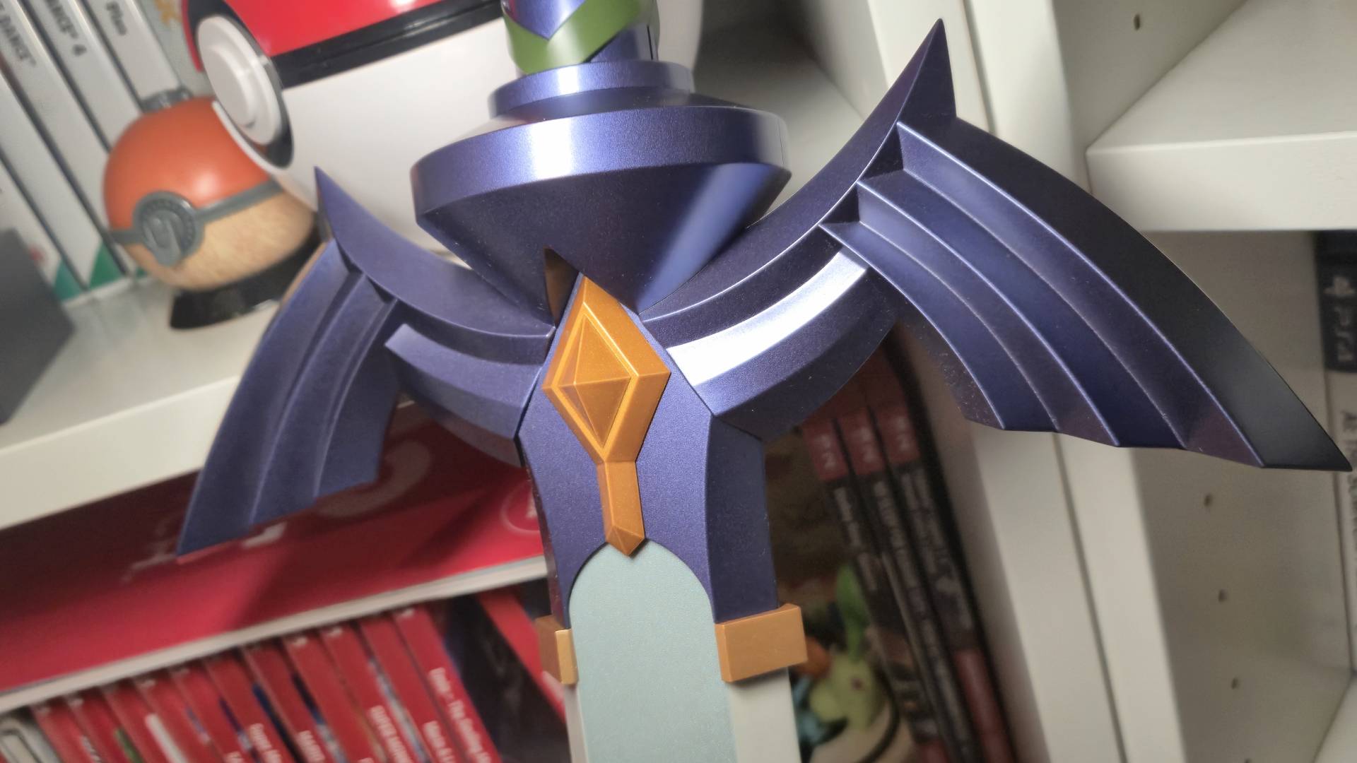 Close up of the Proplica Legend of Zelda Master Sword with Switch games behind it.