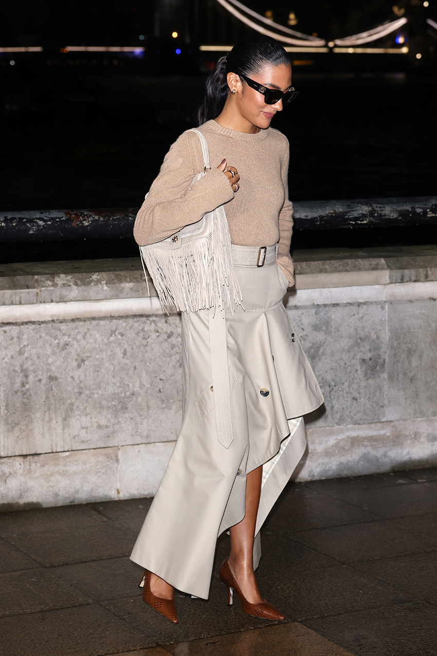 Oliva Dean wearing a tan sweater, beige asymmetrical skirt, and pointed toe heels