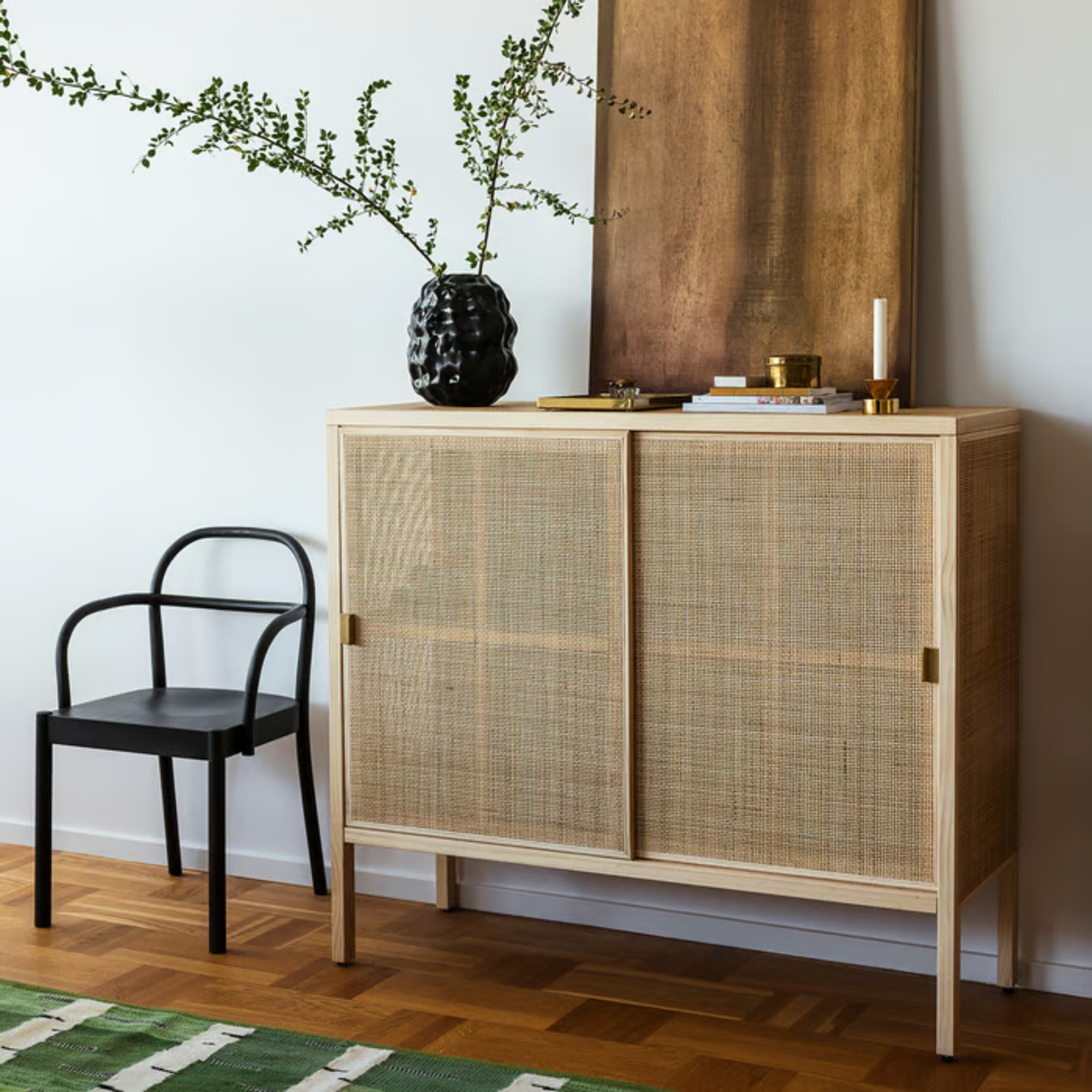 IKEA STOCKHOLM 2025 Cabinet with sliding doors styled with a vase and an abstract painting