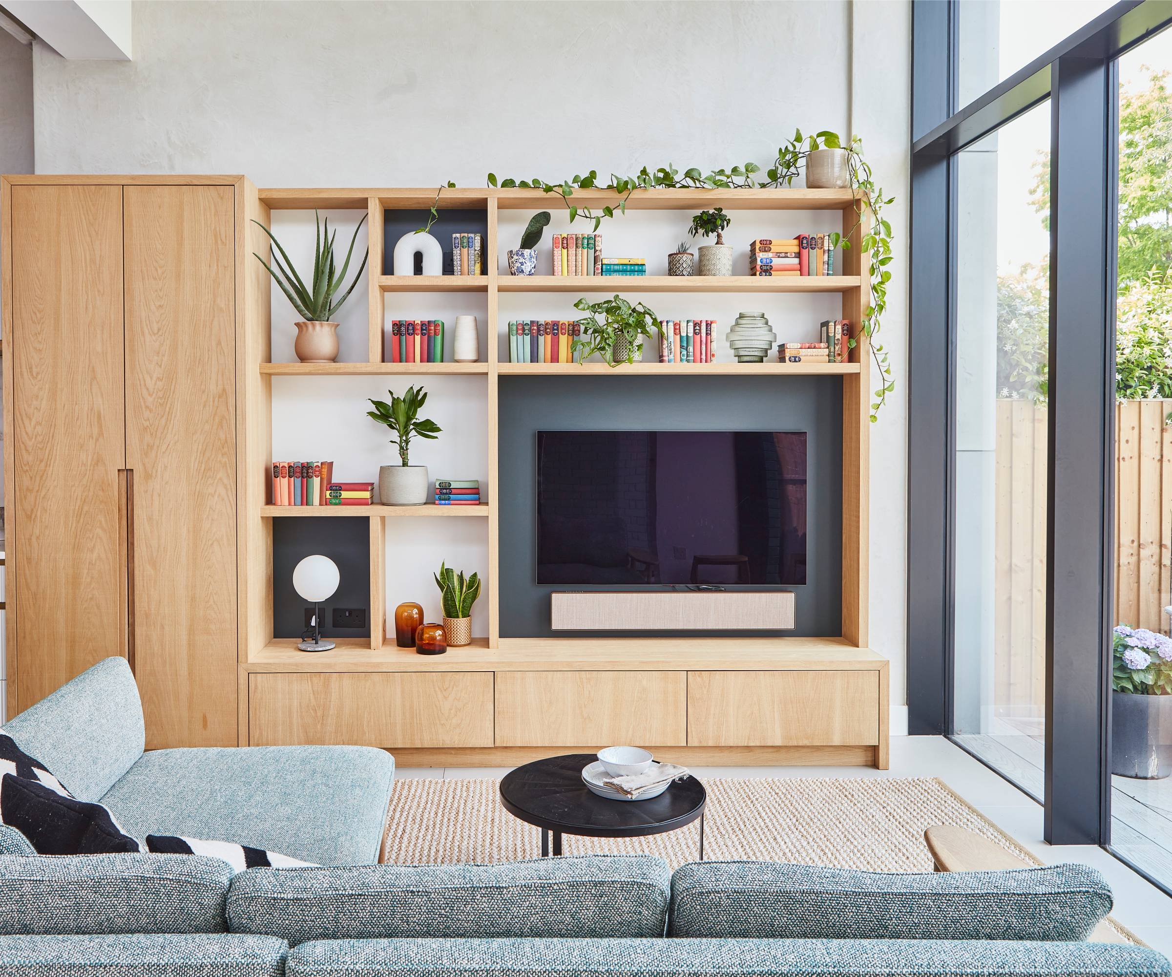 wooden living room media wall with three sections painted dark grey