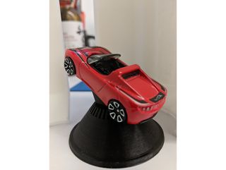 A toy car mounted inside a 3D model of a Falcon Heavy payload fairing.