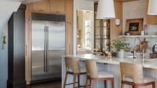 a rustic wood kitchen with an island and a large built in stainless steel fridge