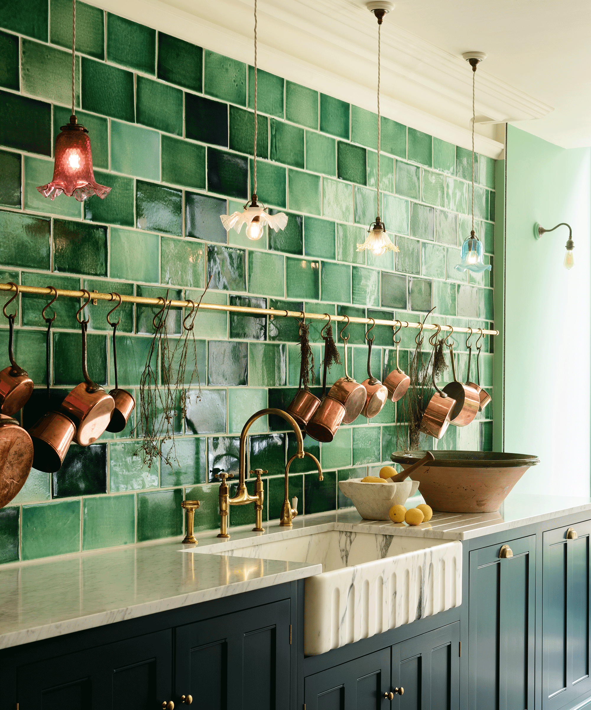 kitchen with pendant lights and green wall tiles with copper pans