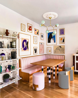 dining room with pink banquette seat, gallery wall, chandelier, and stools