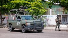 Mexican Army members stand guard after a cartel attack in Culiacán.