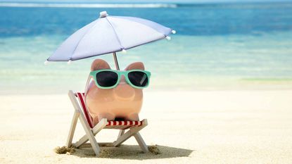 piggy bank sitting in umbrella chair at the beach