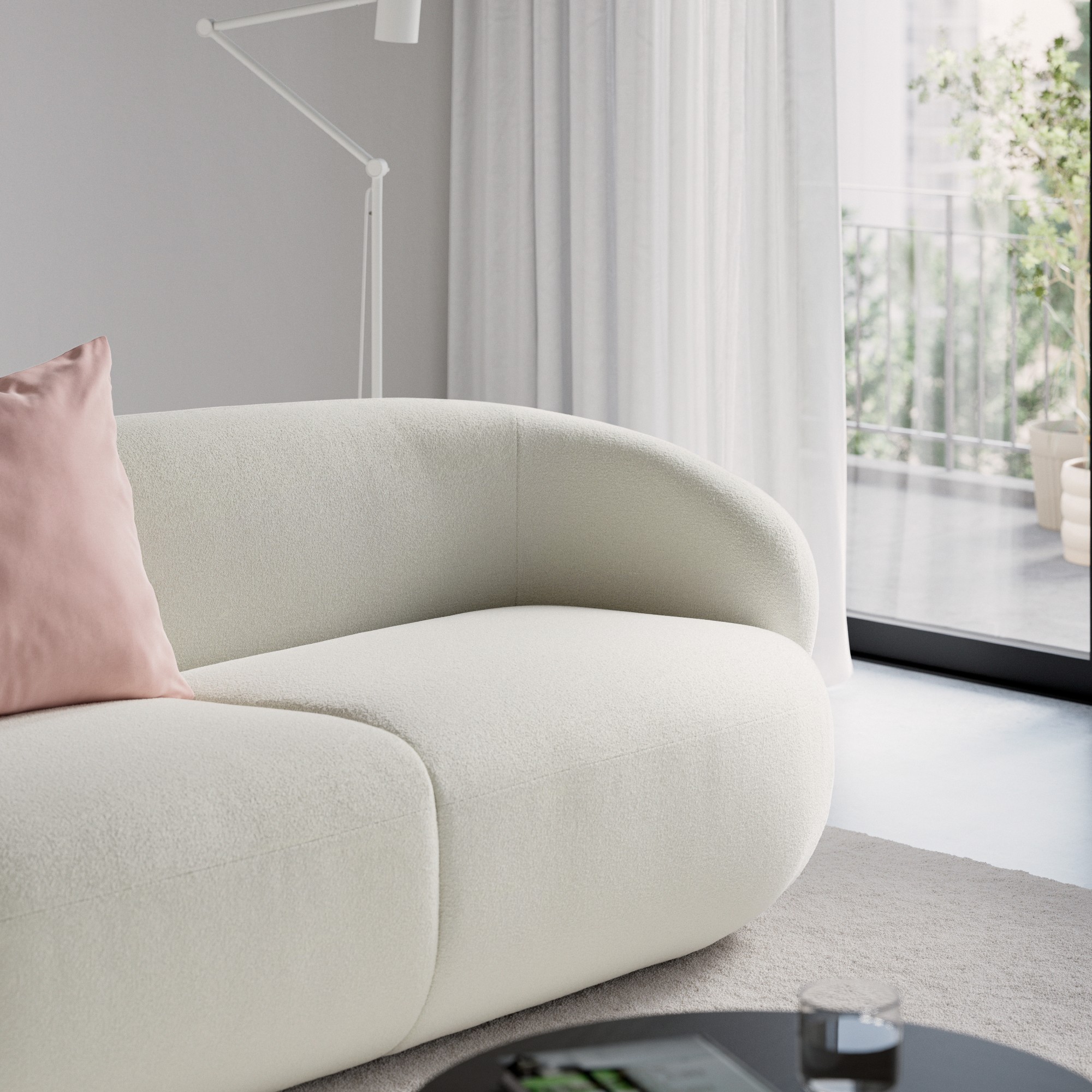 A close-up of the curve of the off-white IKEA LILLESATER sofa in a living room