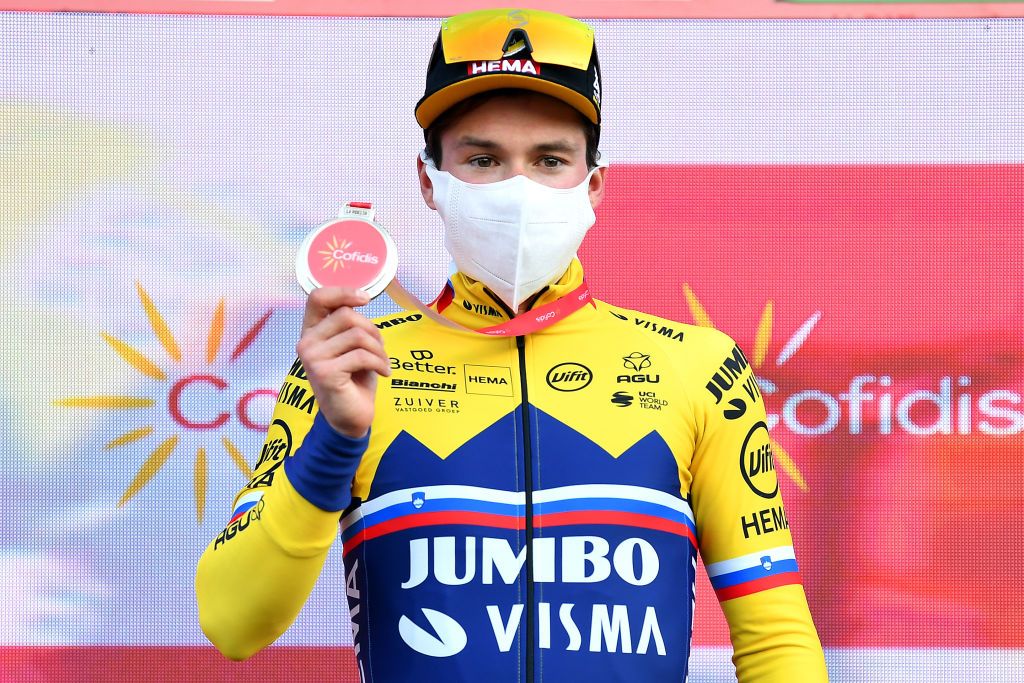 SUANCES SPAIN OCTOBER 30 Podium Primoz Roglic of Slovenia and Team Jumbo Visma Celebration Mask Covid safety measures Trophy during the 75th Tour of Spain 2020 Stage 10 a 185km stage from Castro Urdiales to Suances lavuelta LaVuelta20 La Vuelta on October 30 2020 in Suances Spain Photo by Justin SetterfieldGetty Images