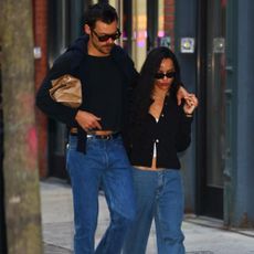 Harry Styles in a long-sleeve shirt and jeans with Zoe Kravitz