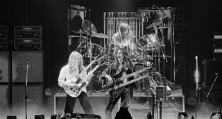 Rush in their pomp as they perform on the Farewell To Kings tour in 1967, with both Alex Lifeson and Geddy Lee playing double-neck guitars. Neil Peart's drum kit is similarly grand.