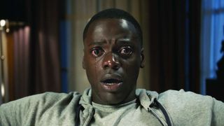 A close up of a teary eyed Chris sitting in a chair in Get Out
