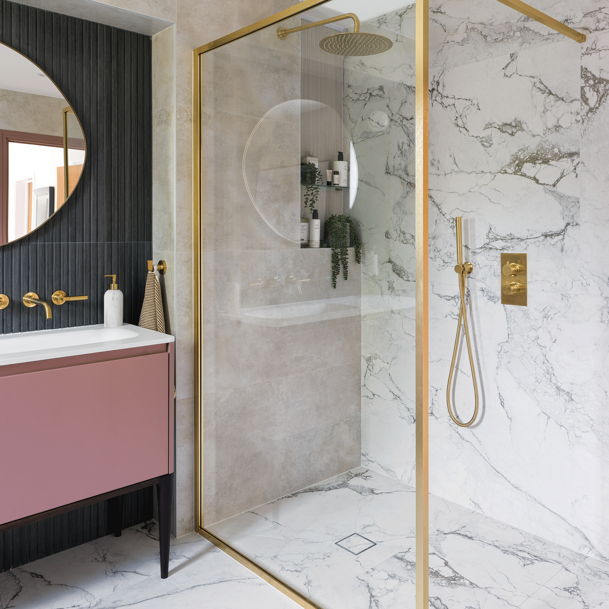 a bathroom with a modern pink vanity unit with sink with a charcoal tiled wall beside a large walk-in shower