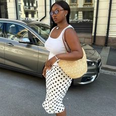 Nnenna Echem wearing a polka dot skirt with a white tank top.