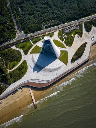 sun tower by open architecture, a curved, sloping, concrete tower, half open to the elements and looking out towards the sea