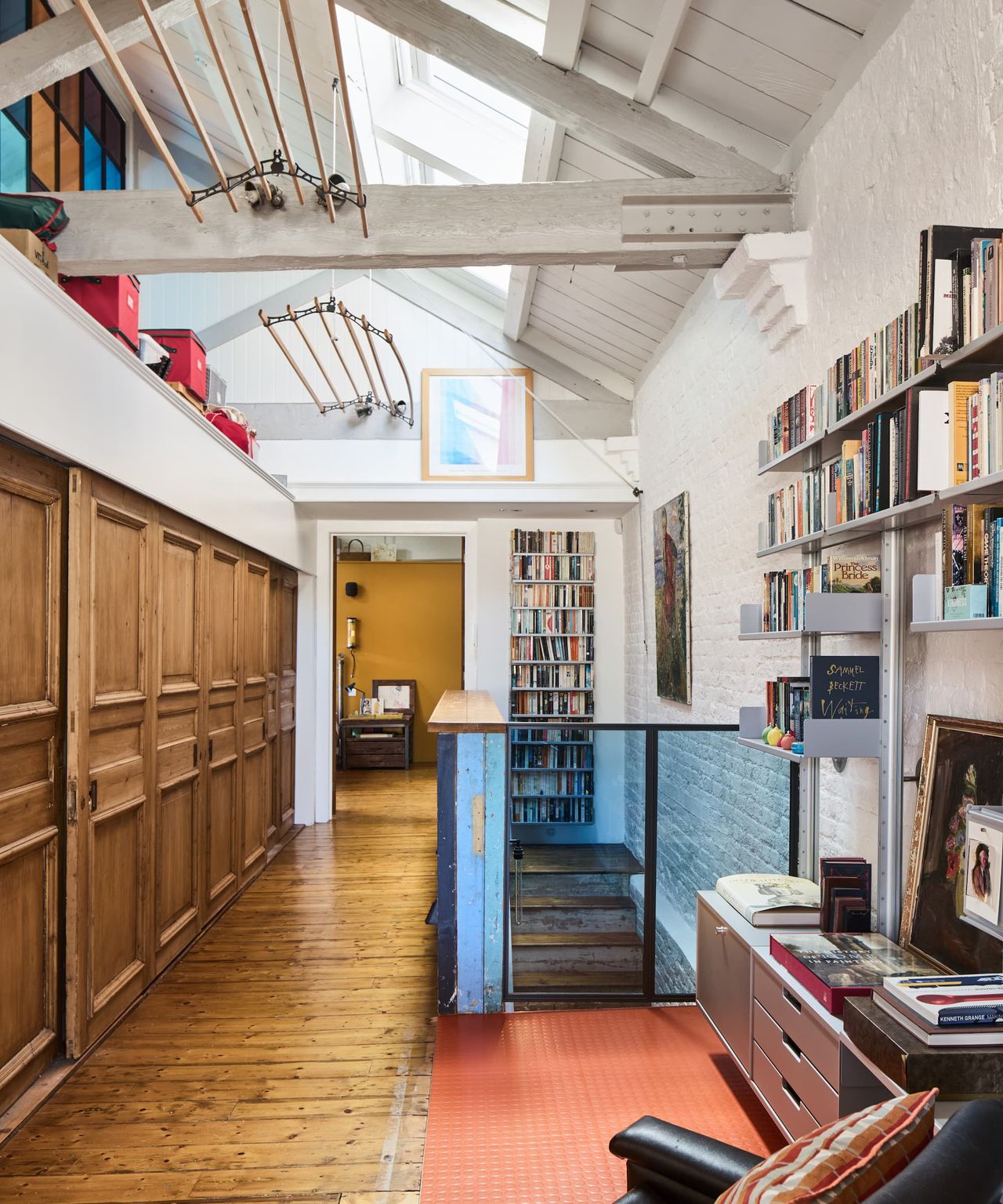 A vaulted ceiling above the top story of a house with white timber and beams running across