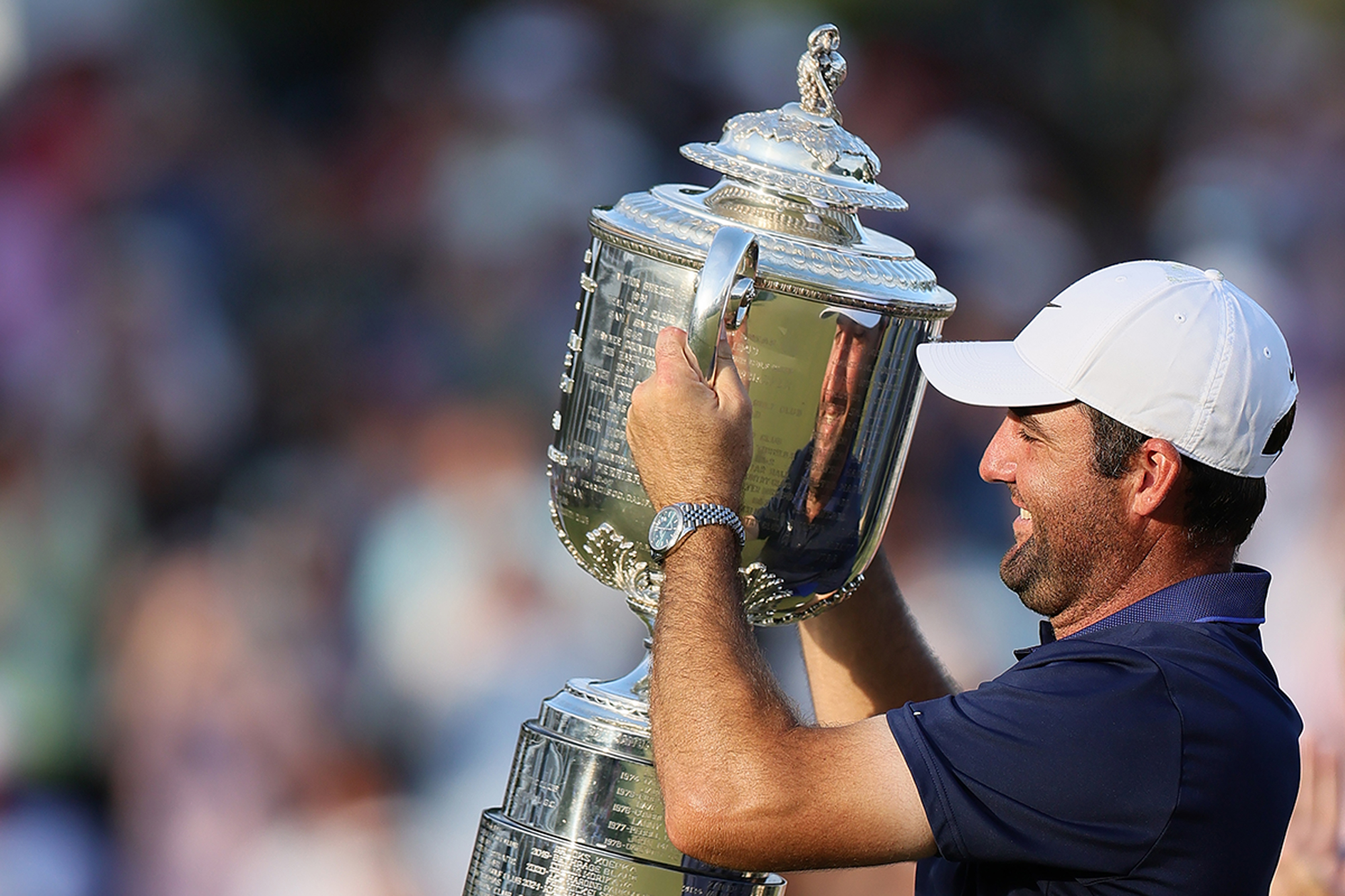 Scottie Scheffler lifting the PGA Championship trophy after winning a third Major title at Quail Hollow