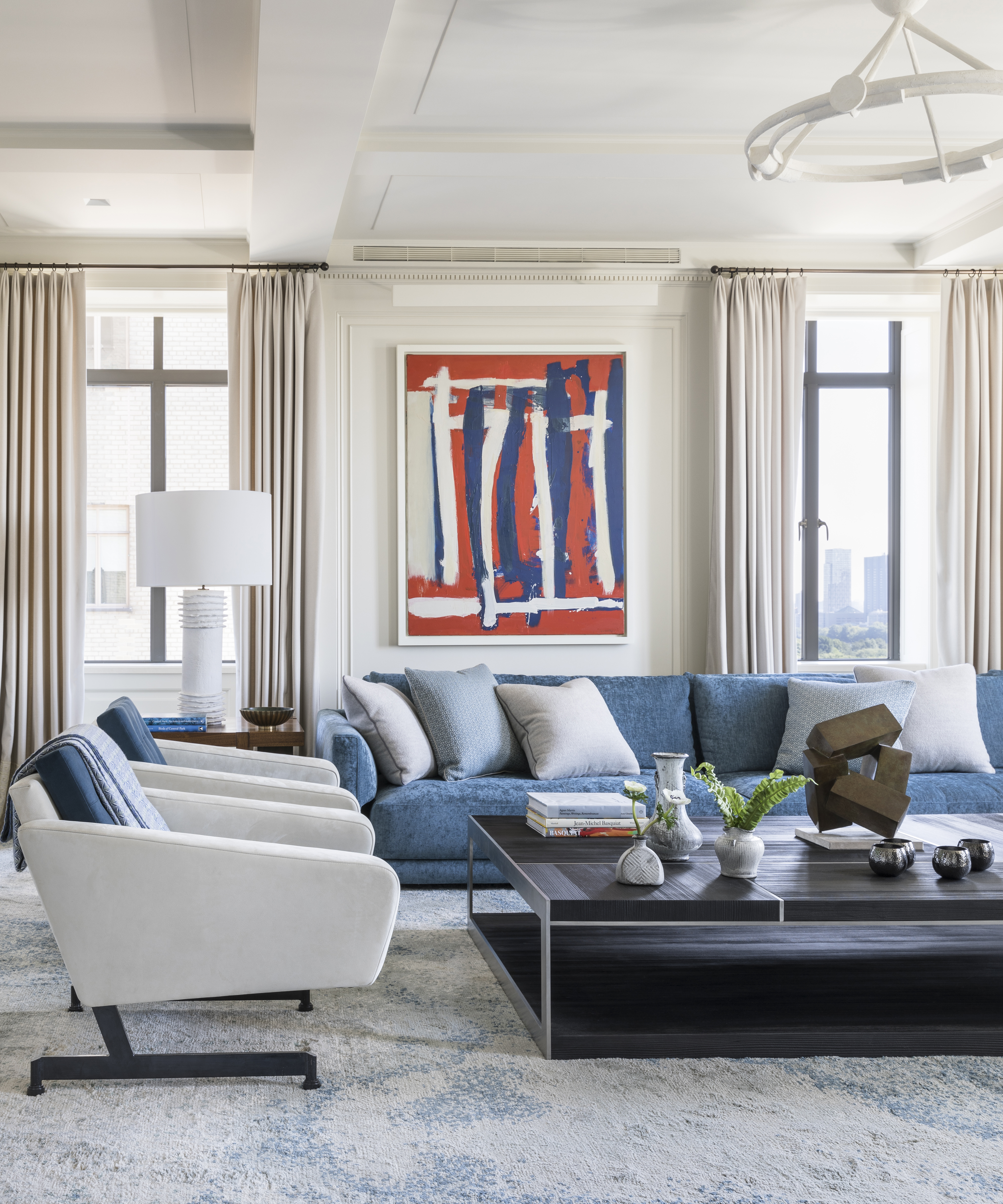 living room with blue sofa and white chairs
