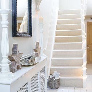 hallway with white wall and white staircase mirror on wall
