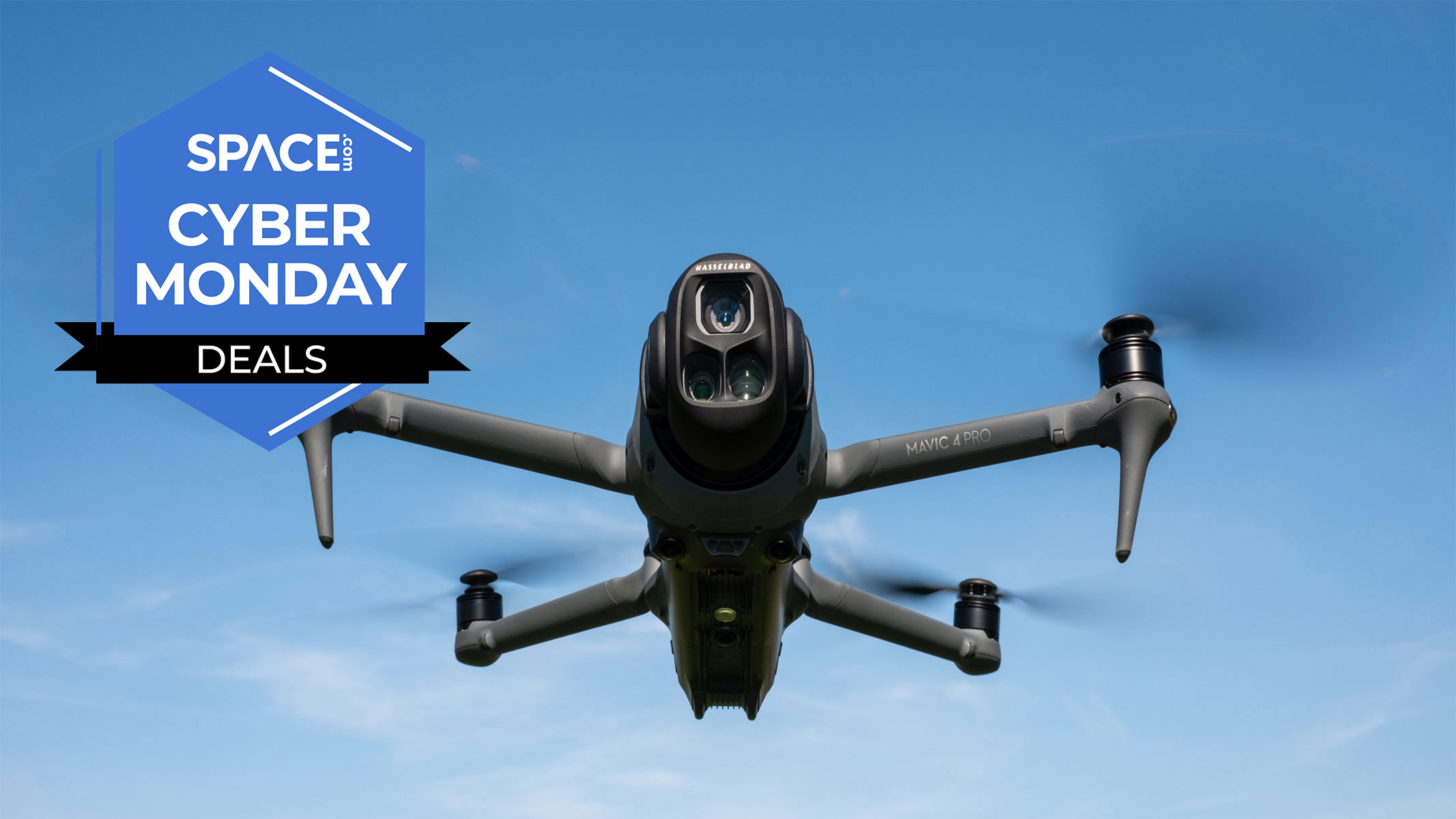 A black quadcopter is hovering in front of blue skies with the space.com logo in the top left corner.