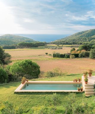 view with swimming pool and rolling hills and sea beyond