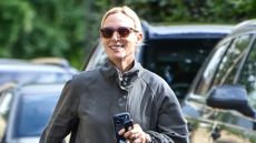 Zara Tindall holds her phone and keys as she arrives for her brother's wedding rehearsal