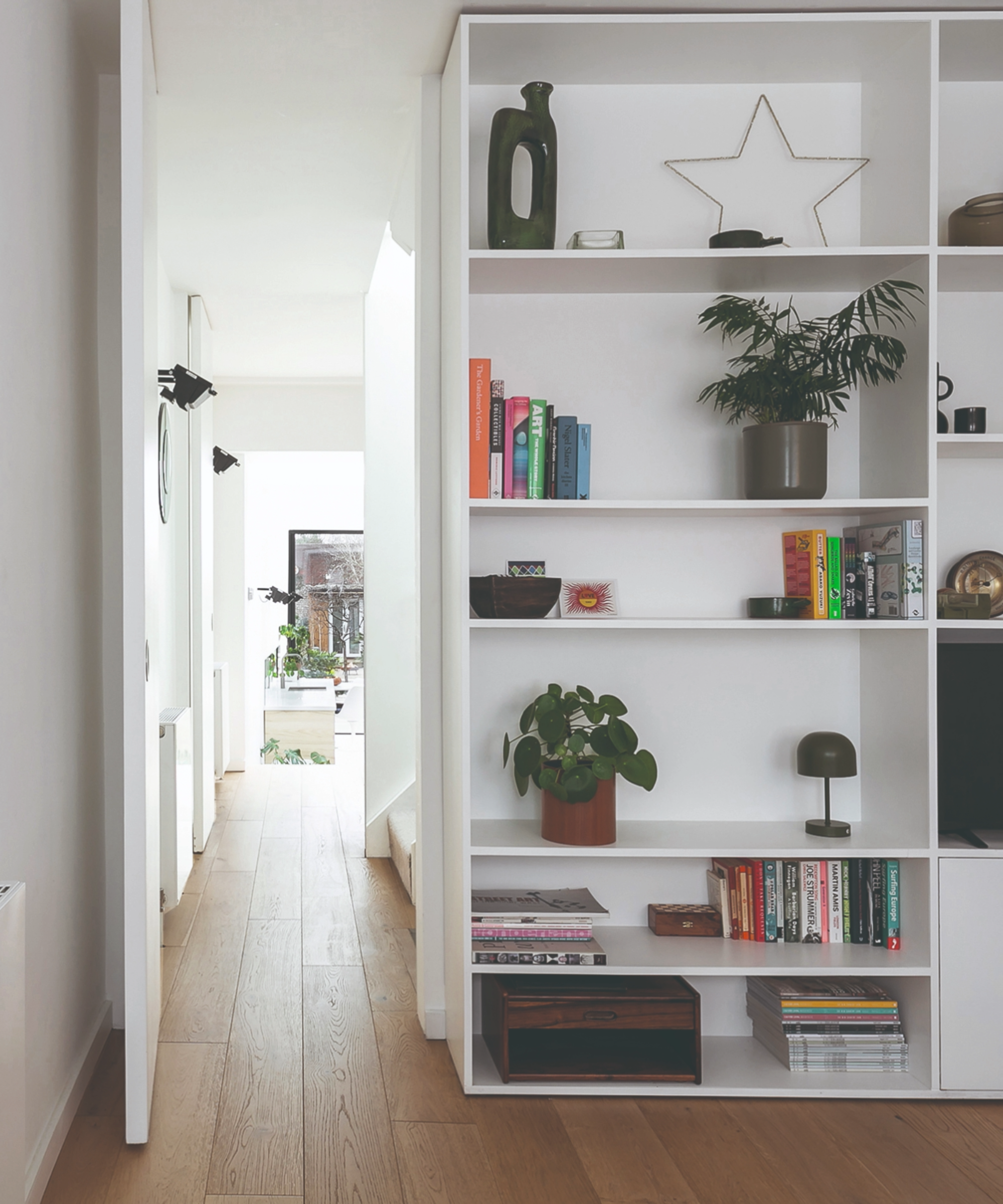 Room with built in storage cabinet that connects to the hallway from the kitchen