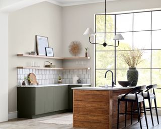 neutral kitchen with beige walls, large windows and wooden island unit