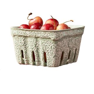 A mint green and white patterned berry basket