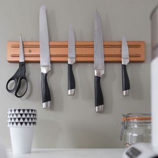 Kitchen knife set set up on grey wall