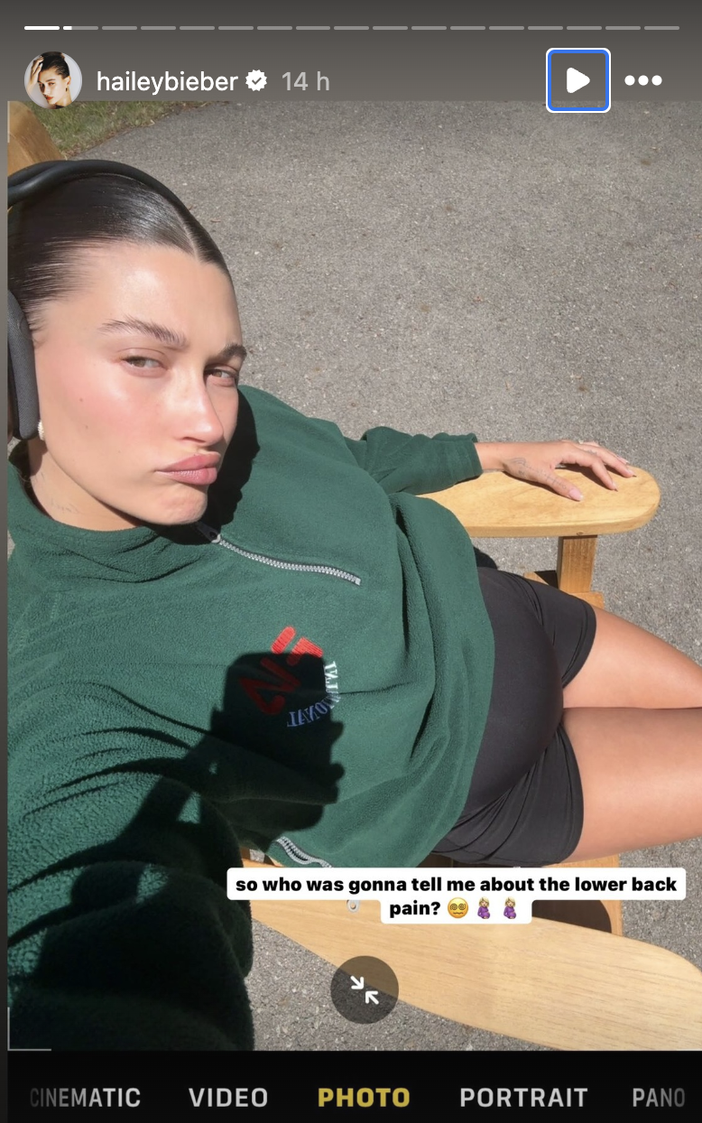 Hailey Bieber wearing a green sweatshirt and black microshorts on Instagram